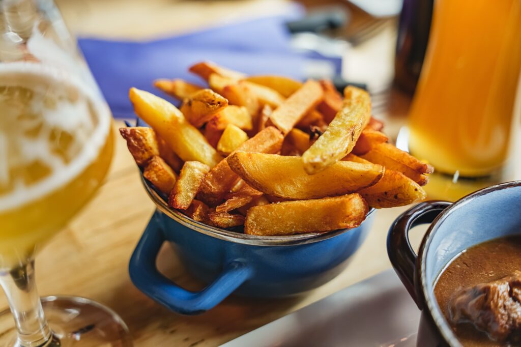 Portion of crispy golden spiced potato wedges, restaurant serving french fries. Potato wedges